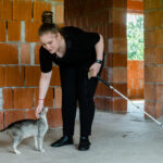 Ali o mângâie pe Insistenta, una din cele zece pisici pe care le are, în timpul unei plimbări în viitoarea casă a bunicilor ei.