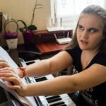 Ali citește partituri de pian în Braille.